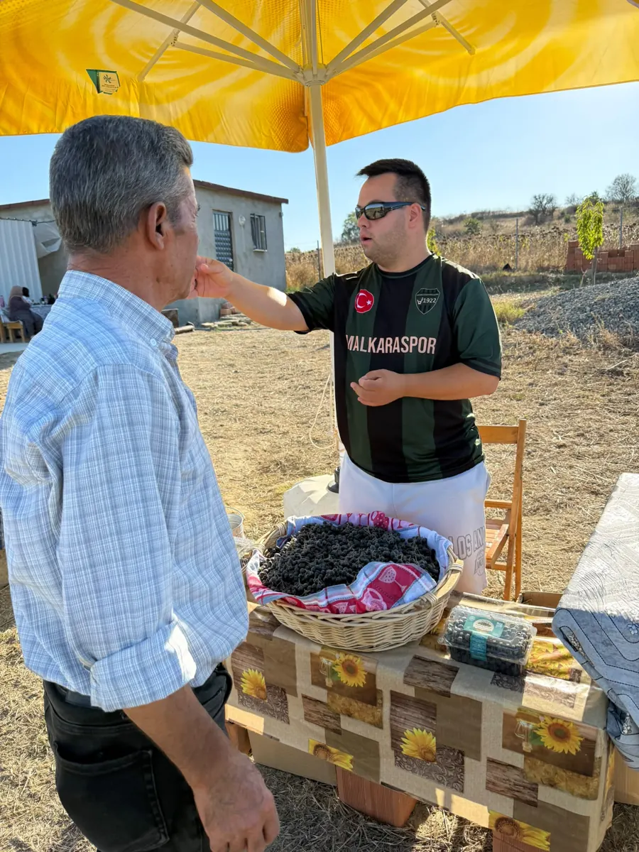 Çiftlik ziyaretinde bir misafire taze aronya tattırılıyor